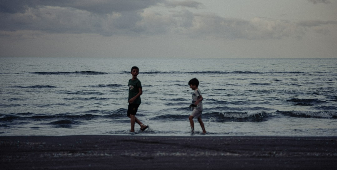 A family with children walks together along a wet beach as the sun breaks through the clouds after a storm, symbolizing hope and resilience.