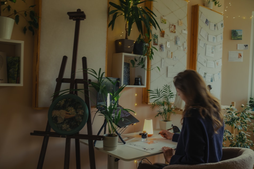 A female entrepreneur carefully packs product orders into shipping boxes at a desk in her home, showcasing the hands-on nature of running a family business.